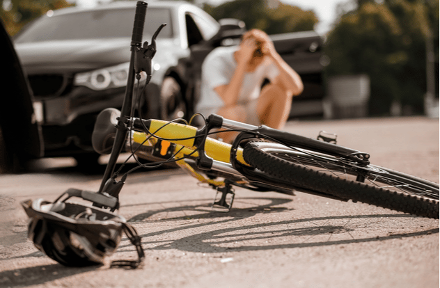 Bicycle and helmet on road and driver near car