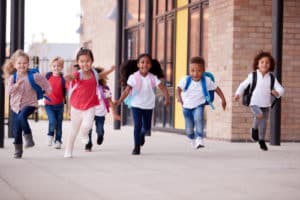 A group of smiling multi ethnic school kids running