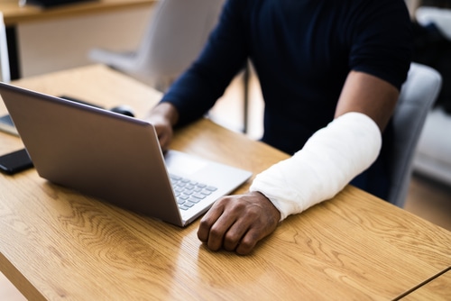 Broken Arm African Man On Computer