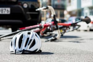 Close up,Of,A,Bicycling,Helmet,Fallen,On,The,Asphalt,Next