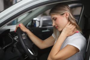 A woman holding her neck after getting in a car accident