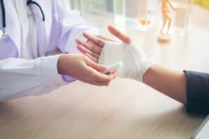 A doctor wrapping a patient’s hand after a burn injury