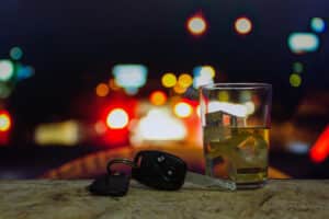 Close up of car keys next to alcoholic beverage to indicate drunk driving