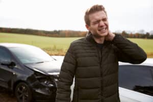 A man holding his neck after an Uber motor vehicle accident