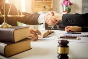 A lawyer and client shaking hands after receiving a lowball settlement offer