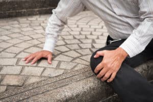 A man holding his knee after a slip-and-fall accident in Boulder, CO