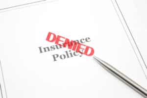 An insurance policy with a red "Denied" stamp