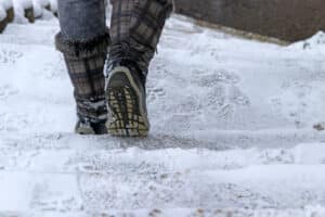 A close-up shot of a person walking in snow boots in Boulder